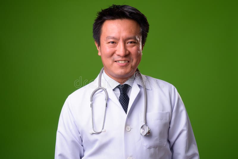Doctor japonés maduro del hombre contra fondo verde imagen de archivo libre de regalías Doctor japonés maduro del hombre contra fondo verde imagen de archivo libre de regalías