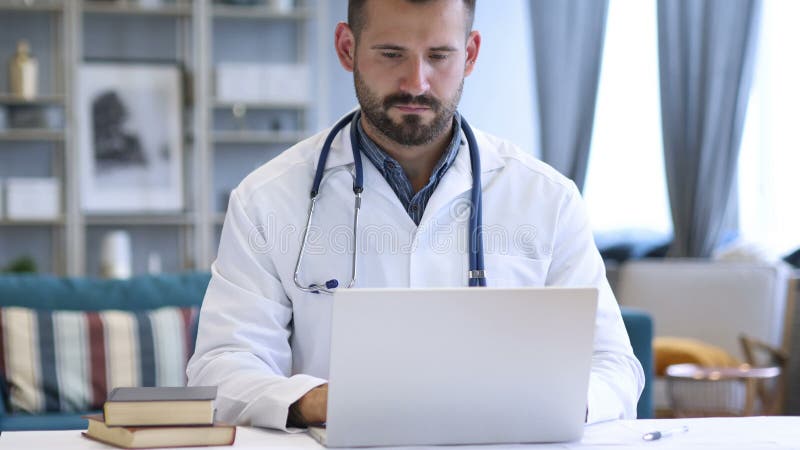 Doctor joven que trabaja en la computadora portátil