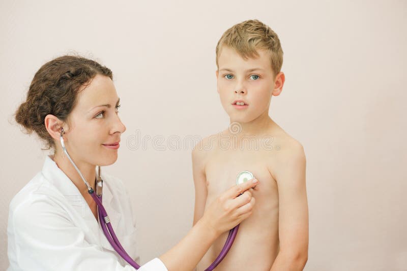 Doctor listens to lungs of boy with stethoscope