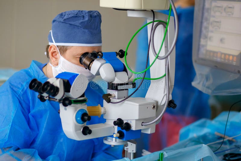 The doctor looks through a microscope, the aphtholmologist performs an operation on the eyes, a scientist examines the eye royalty free stock photos