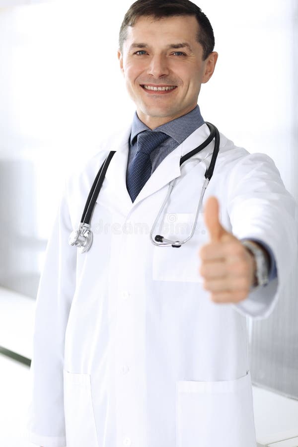 Doctor man cheerful smiling at camera, thumbs up. Perfect medical service in clinic. Happy future in medicine and royalty free stock photo