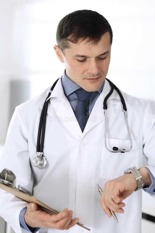 Doctor man using clipboard for filling up medication history records. Perfect medical service in clinic. Physician at stock photos