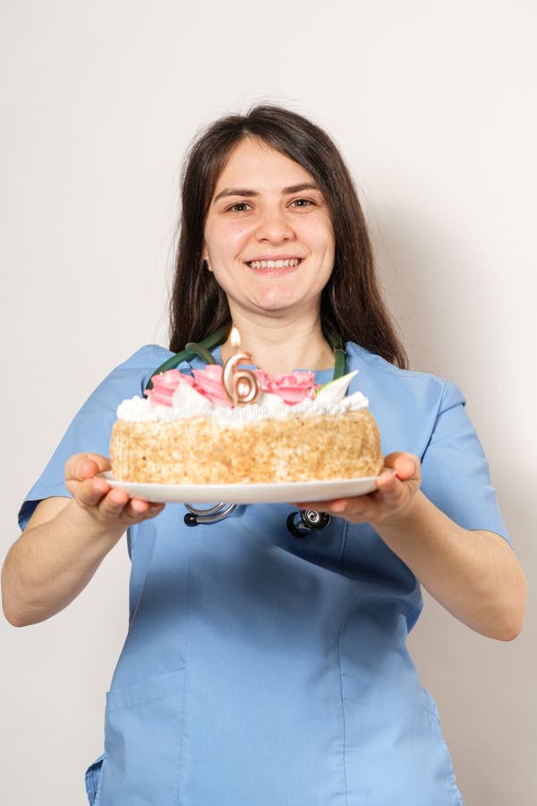 The Doctor or Nurse Holds a Birthday Cake with the Number Six for the