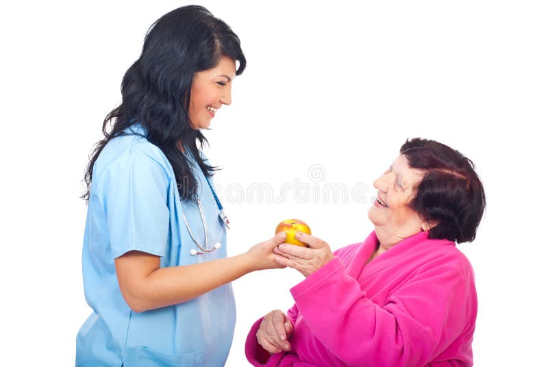 Doctor offering apple to a elderly patient