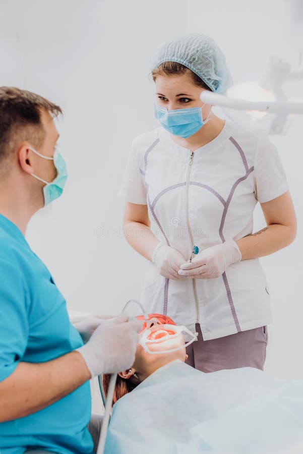Doctor Orthodontist Performs a Procedure for Cleaning Teeth Stock Image