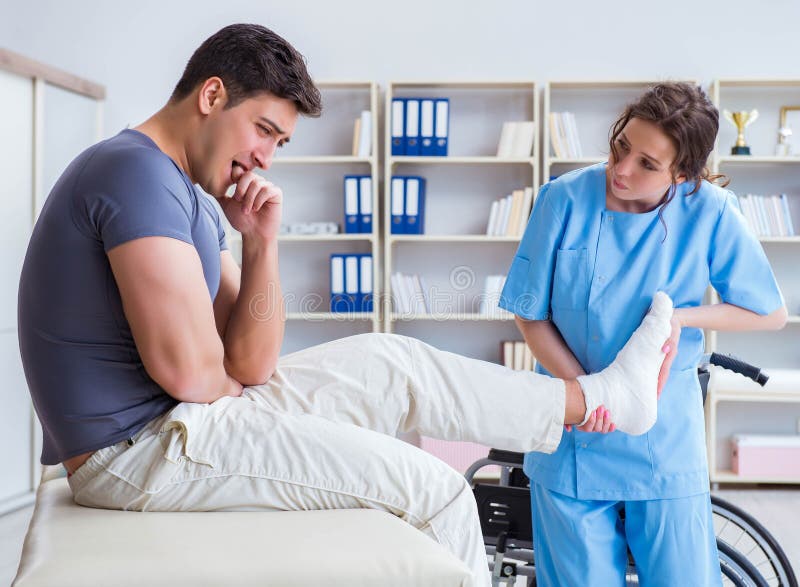 Doctor And Patient During Check Up For Injury In Hospital Stock Image