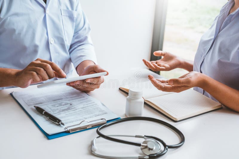 Doctor with patient presenting about Treatment guidelines on digital tablet at office royalty free stock photos Doctor with patient presenting about Treatment guidelines on digital tablet at office royalty free stock photos