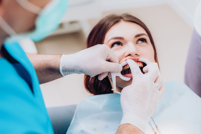 Doctor Orthodontist Performs a Procedure for Cleaning Teeth Stock Image