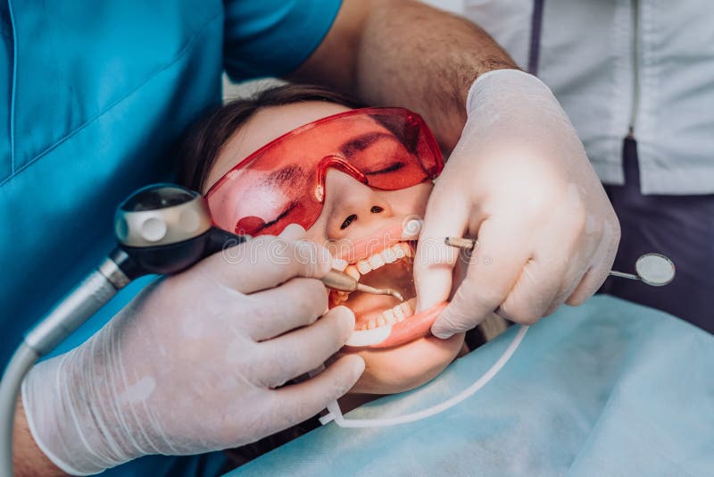 Doctor Orthodontist Performs a Procedure for Cleaning Teeth Stock Image