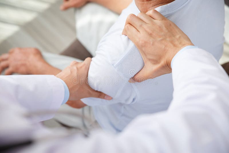 Doctor physiotherapist doing healing treatment to old man. Shoulder pain patient, medical doctor, treatment, massage therapist.