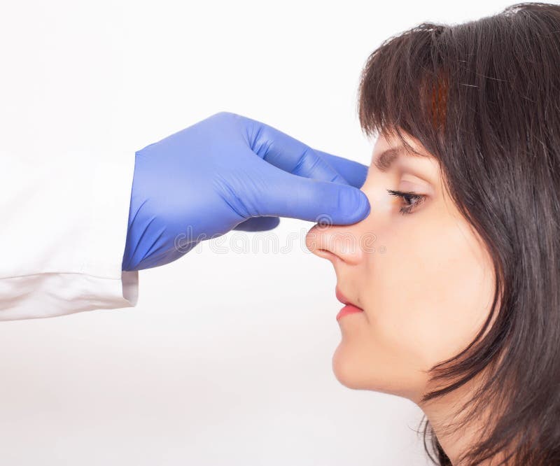 Doctor plastic surgeon prepares a caucasian girl for nose plastic surgery. Rhinoplasty