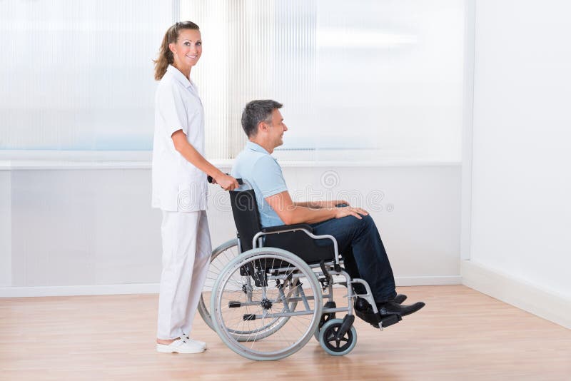 Doctor Pushing Disabled Patient In Wheel Chair Stock Photo - Image of ...