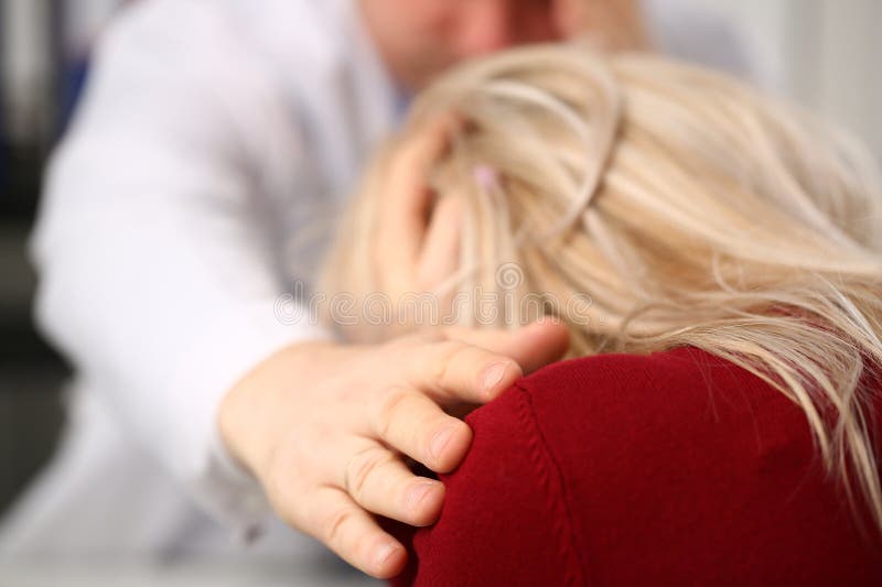 Doctor puts hand on shoulder of patient and sympathetically consoles