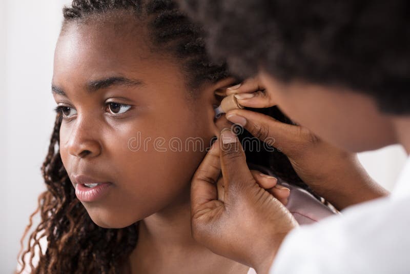 Doctor Putting Hearing Aid In Patient`s Ear