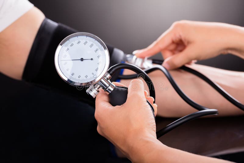 Doctor que controla la presión arterial del paciente