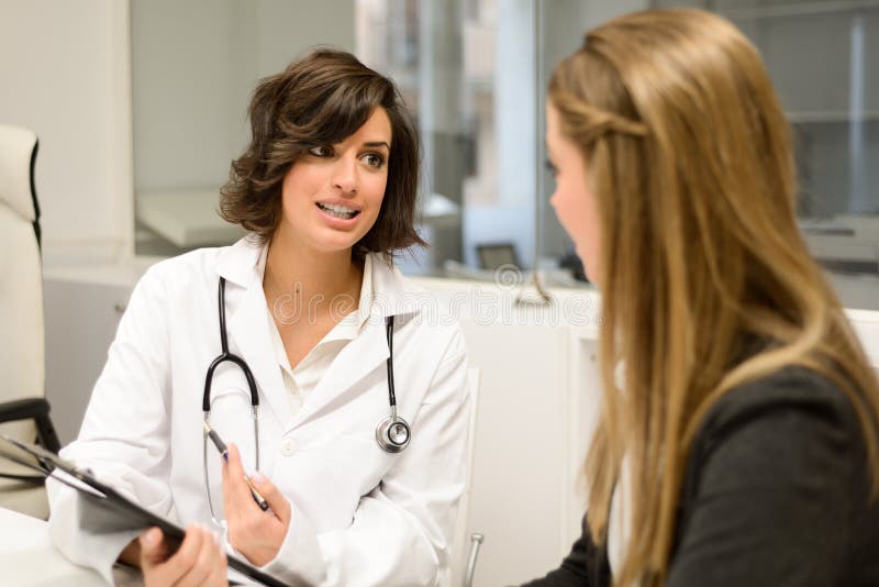 Doctor que explica diagnosis a su paciente femenino imágenes de archivo libres de regalías Doctor que explica diagnosis a su paciente femenino imágenes de archivo libres de regalías