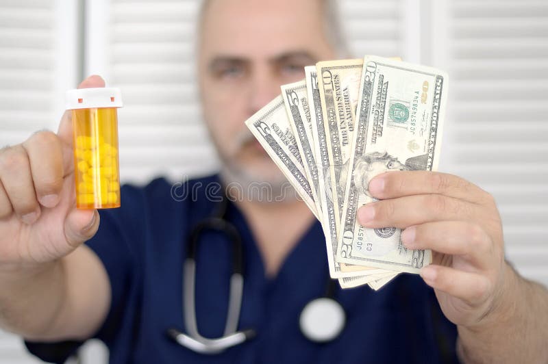 Doctor que sostiene efectivo y píldoras imagen de archivo libre de regalías Doctor que sostiene efectivo y píldoras imagen de archivo libre de regalías