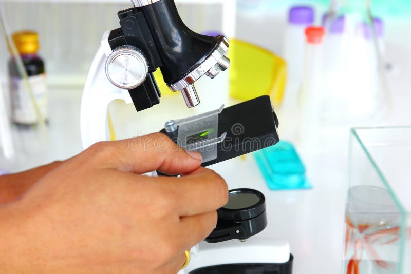 The doctor with lab equipment in clean room using microscope looking the sample and record. royalty free stock photography