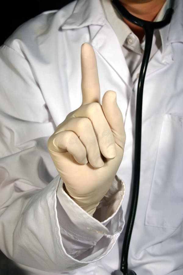 A doctor with a white coat and stethoscope holding up a gloved hand, with the index finger raised. A doctor with a white coat and stethoscope holding up a gloved hand, with the index finger raised.