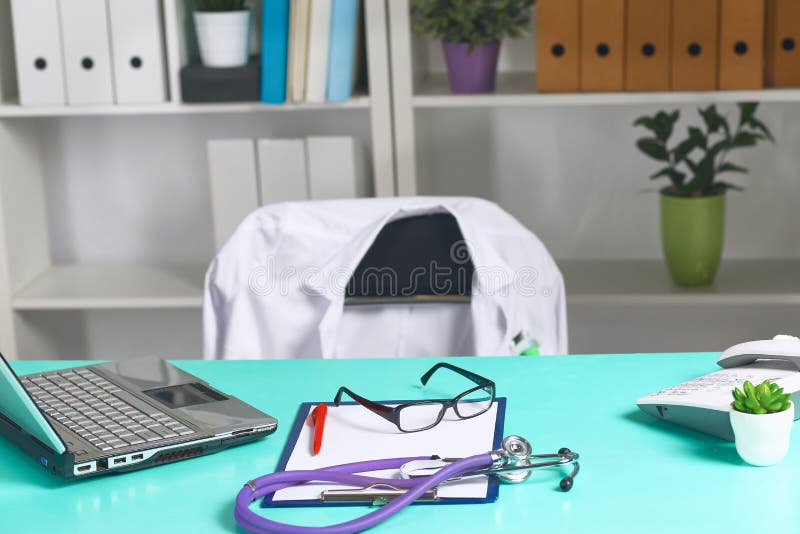 Doctor`s workspace working table with patient`s discharge blank paper form, medical prescription, stethoscope on desk