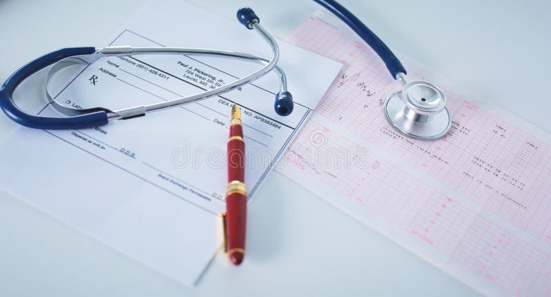 Doctor`s workspace working table with patient`s discharge blank paper form, medical prescription, stethoscope on desk