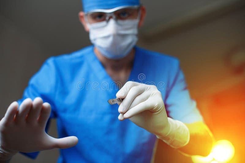 Doctor with a scalpel against a bright operating light. royalty free stock images Doctor with a scalpel against a bright operating light. royalty free stock images