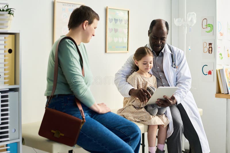 Doctor Using Tablet While Consulting with Child and Parent royalty free stock photos