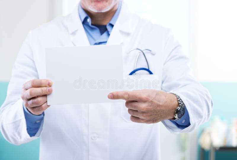Doctor pointing at a small white sign, a message can be added. Doctor pointing at a small white sign, a message can be added.