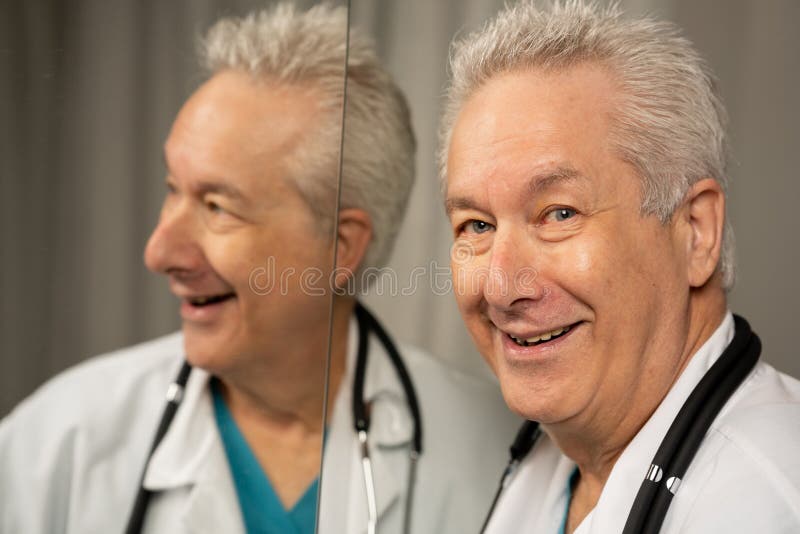 Doctor Smiling Over Shoulder with Reflection in the Mirror Stock Photo