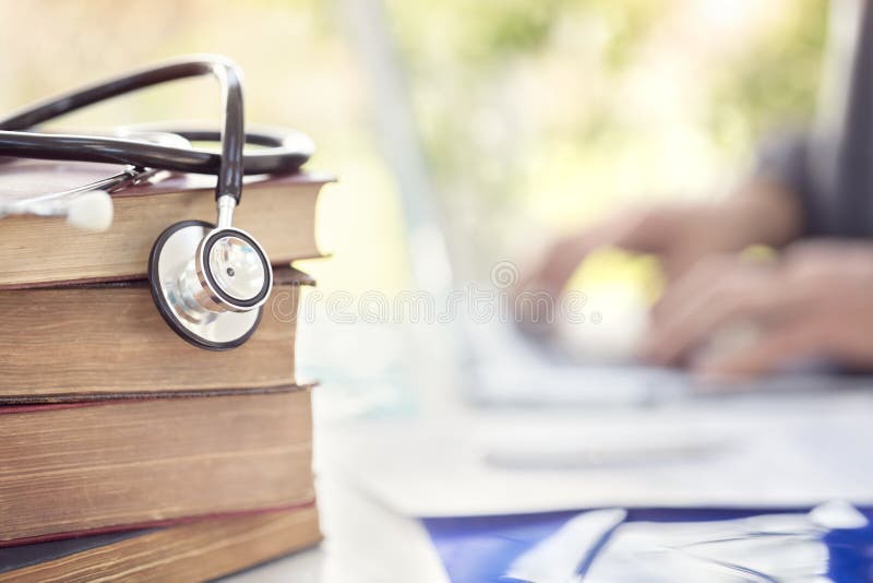 Doctor or student at medical college with books and stethoscope. Doctor or student at medical college with stack of books and stethoscope stock photos Doctor or student at medical college with books and stethoscope. Doctor or student at medical college with stack of books and stethoscope stock photos
