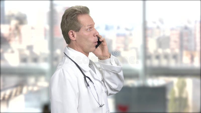 Doctor talking on phone, blurred backgroud.