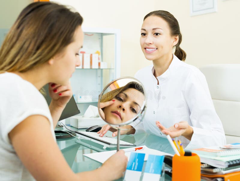 Doctor talking to female visitor in aesthetic medicine center