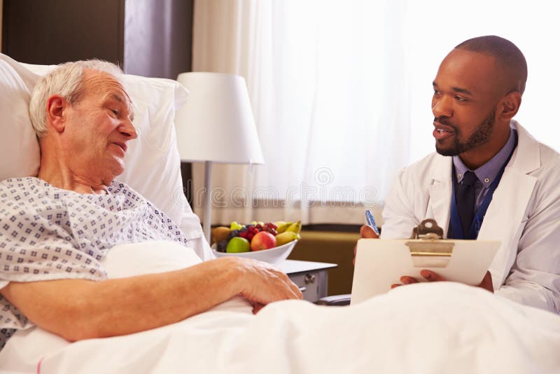 Doctor Talking To Senior Male Patient In Hospital Bed