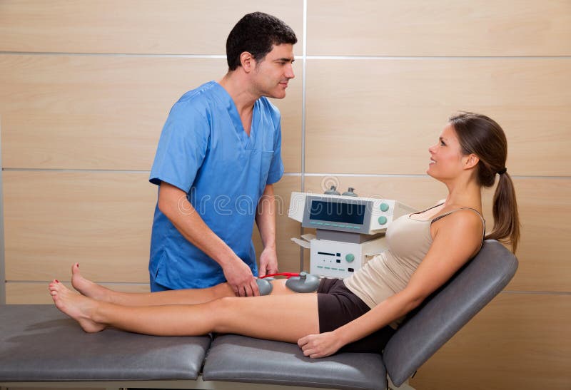 Doctor therapist checking muscle electrostimulation to woman stock image Doctor therapist checking muscle electrostimulation to woman stock image