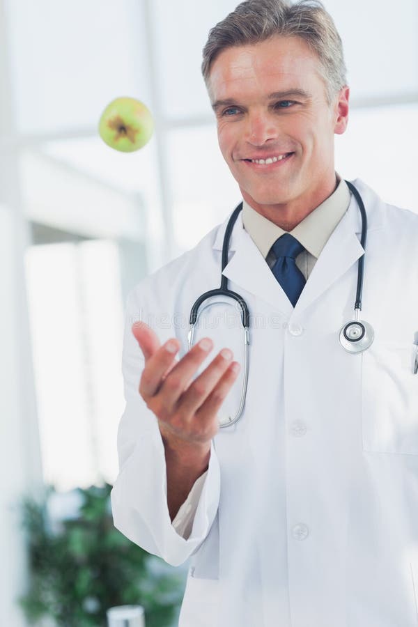 Doctor Throwing a Green Apple Stock Photo Image of hair, specialist