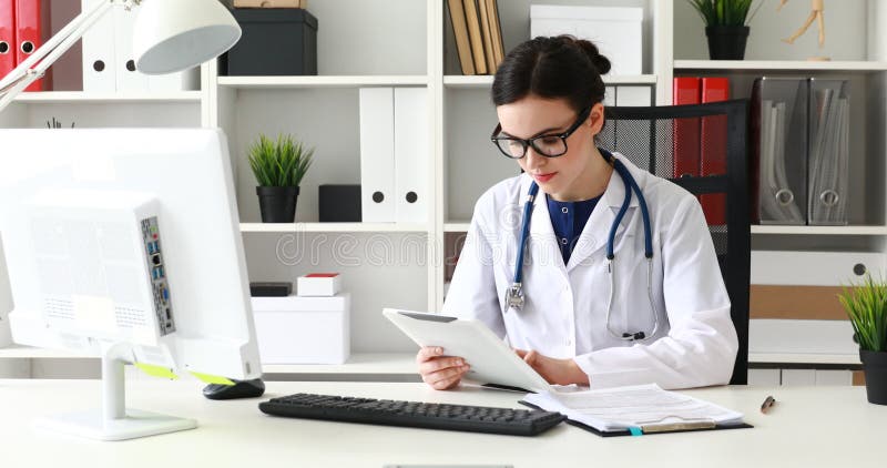 Doctor typing text on white tablet in office stock video