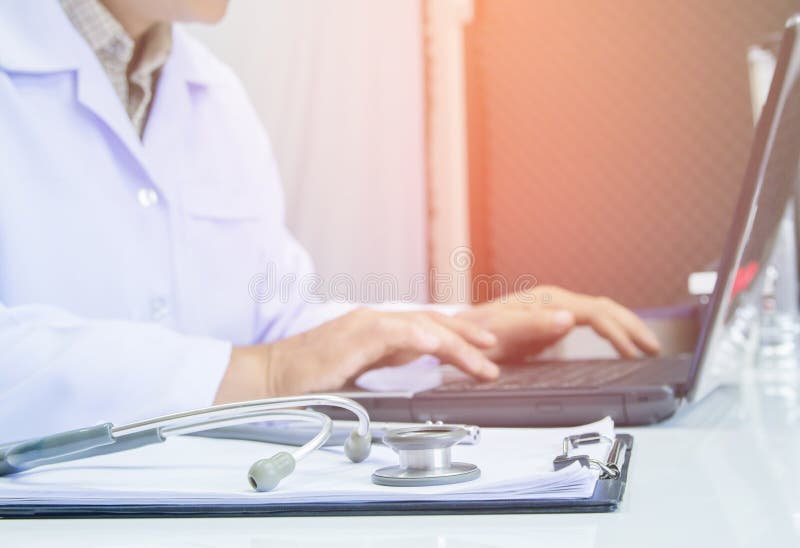The doctor using digital labtop computer medical working information with stethoscope on desk royalty free stock photography The doctor using digital labtop computer medical working information with stethoscope on desk royalty free stock photography