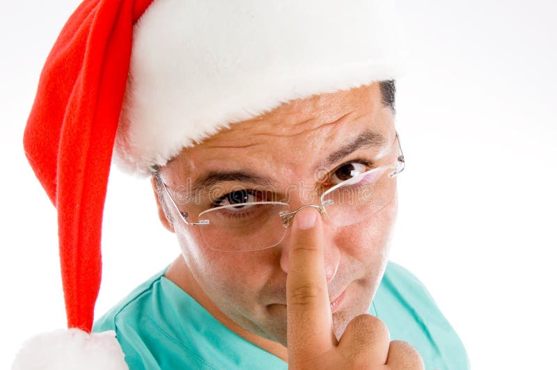 Doctor wearing santa hat adjusting his glasses