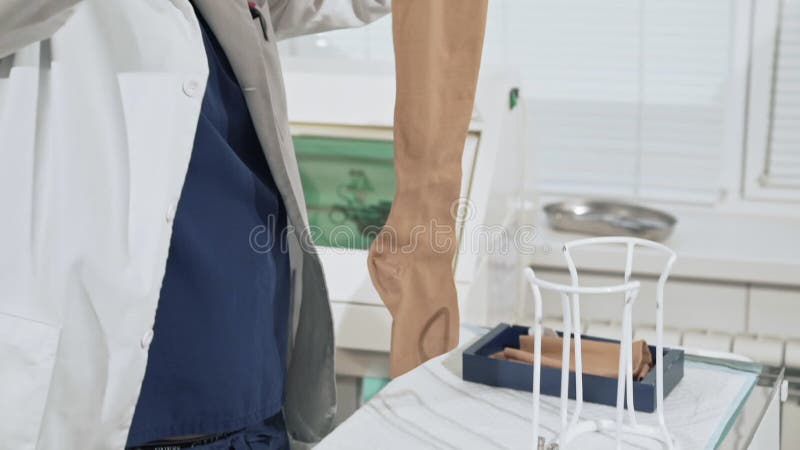 A doctor with a white medical robe prepares compression stockings before surgery. Medical instruments in the surgical