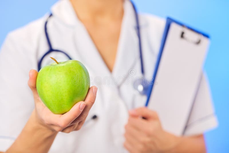 Doctor (woman) holding green apple