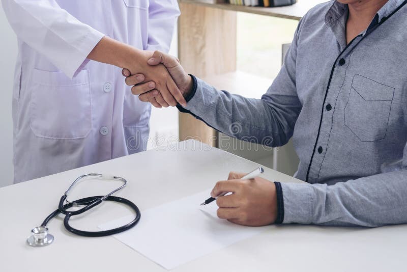 Doctor y paciente que sacuden las manos después del tratamiento imagenes de archivo Doctor y paciente que sacuden las manos después del tratamiento imagenes de archivo