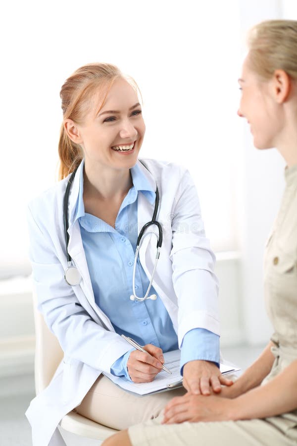 Doctor y paciente que tienen una charla del placer mientras que se sienta en las sillas en la oficina del hospital Cuidado médico foto de archivo Doctor y paciente que tienen una charla del placer mientras que se sienta en las sillas en la oficina del hospital Cuidado médico foto de archivo