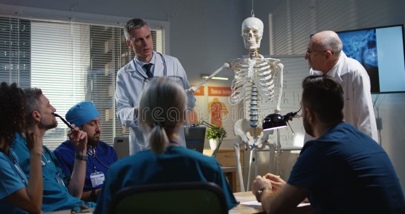 Doctores que explican diagnosis a sus colegas imagen de archivo libre de regalías