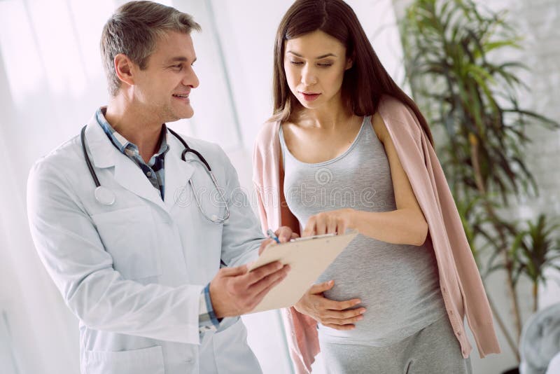 Nice pregnant woman pointing at the notes royalty free stock images Nice pregnant woman pointing at the notes royalty free stock images
