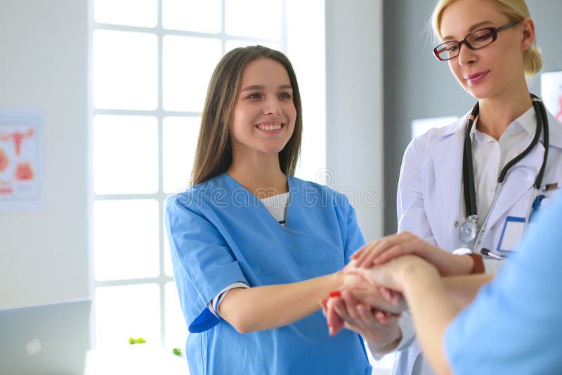 Doctors and nurses in a medical team stacking hands. Diverse medical team stock images, royalty-free photos and pictures