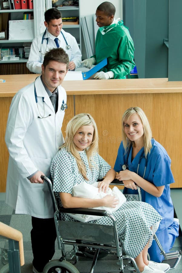 Doctors with a patient in a wheel chair and two doctors in the background. Doctors with a patient in a wheel chair and two doctors in the background