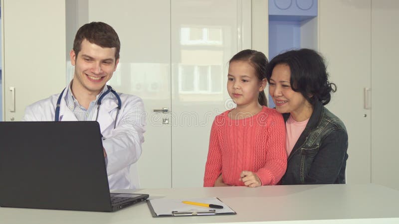 Doctors shows little girl and her mother something on laptop stock photos Doctors shows little girl and her mother something on laptop stock photos