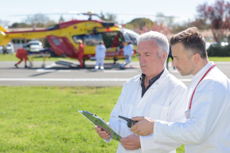 Doctors standing by helicopter checking patients record royalty free stock photos Doctors standing by helicopter checking patients record royalty free stock photos