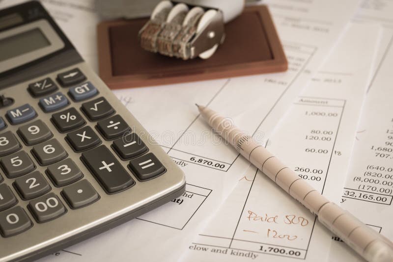 Close up a calculator on office document with pen and rubber stamp. Close up a calculator on office document with pen and rubber stamp