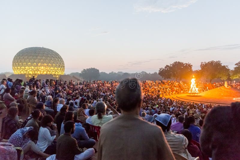 AUROVILLE, TAMIL NADU, INDIA - February 28, 2018. Collective Meditation with dawn fire. On Auroville`s 50 years Birthday, at the Matrimandir Amphitheater. AUROVILLE, TAMIL NADU, INDIA - February 28, 2018. Collective Meditation with dawn fire. On Auroville`s 50 years Birthday, at the Matrimandir Amphitheater